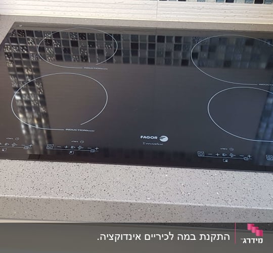 כיריים על משטח שיש אפור עם נקודות לבנות
